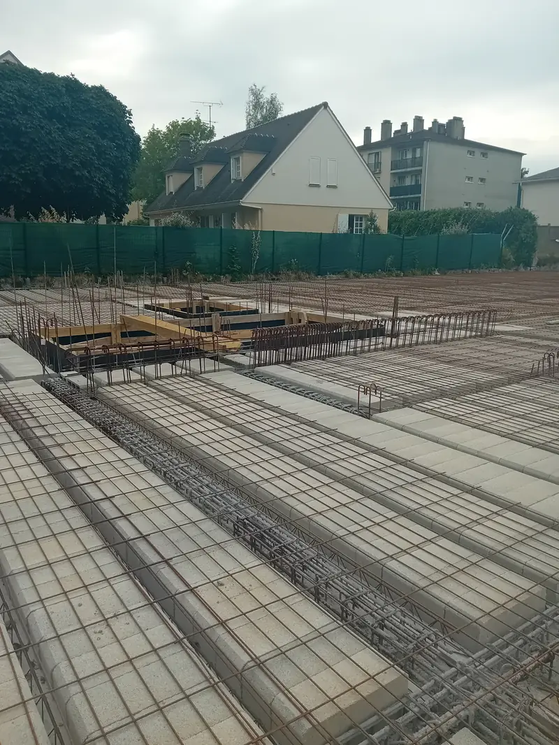 Plancher en poutrelles et entrevous béton recouvert de treillis soudé et d’armatures, avant coulage.