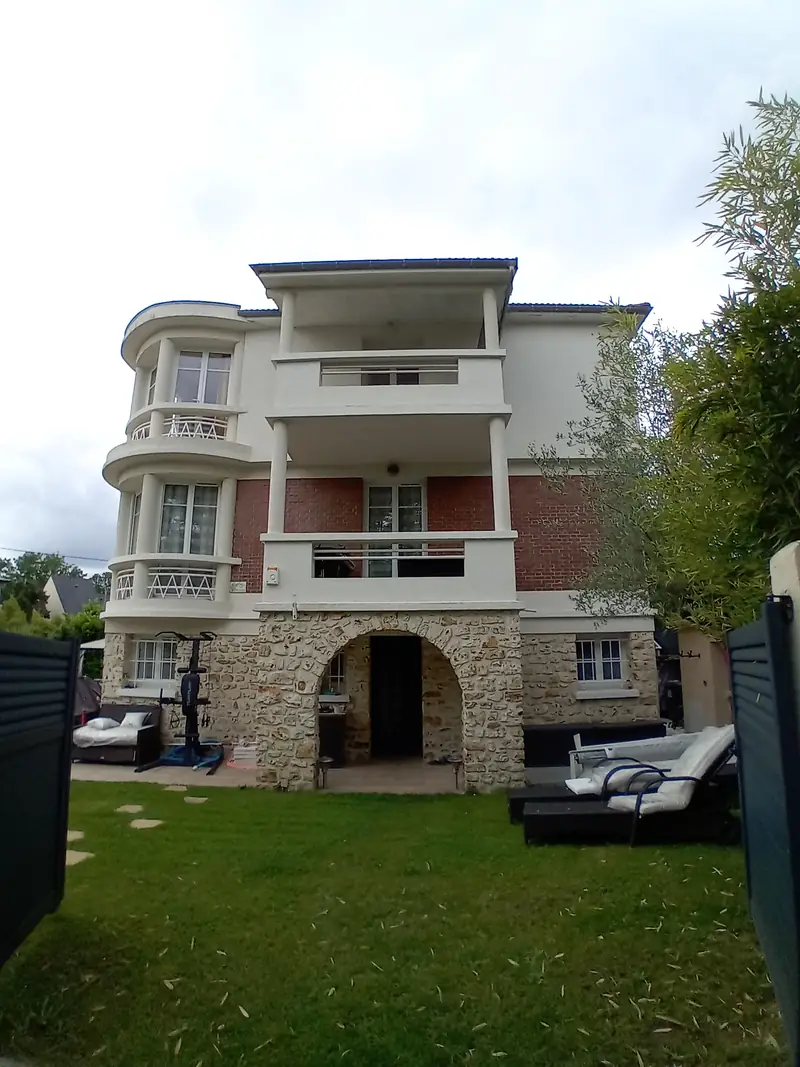 Villa vue depuis la pelouse du jardin, arcades en meulière au rez-de-chaussée.